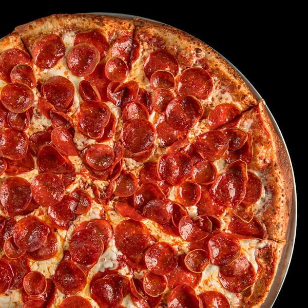 Close-up of a Pijja Paradise pepperoni pizza with a crispy crust and melted cheese.